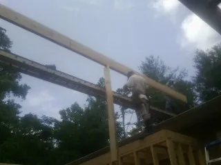 Carpenter setting a ridge beam over a new addition frame — Ice Dam Removal by Roofing Brothers in Brookfield