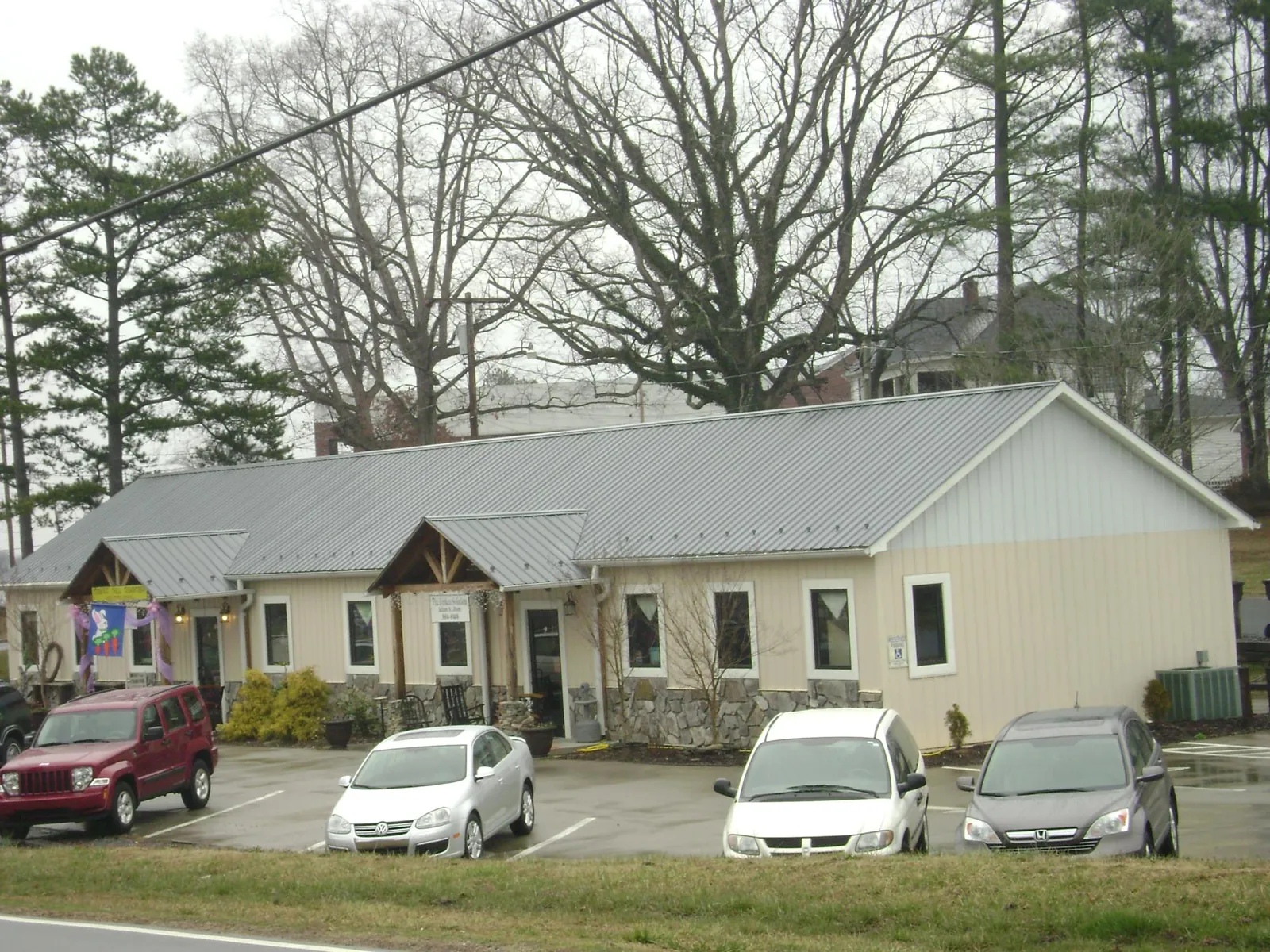 Gray metal roof with timber entry brackets on a small commercial building in Brookfield