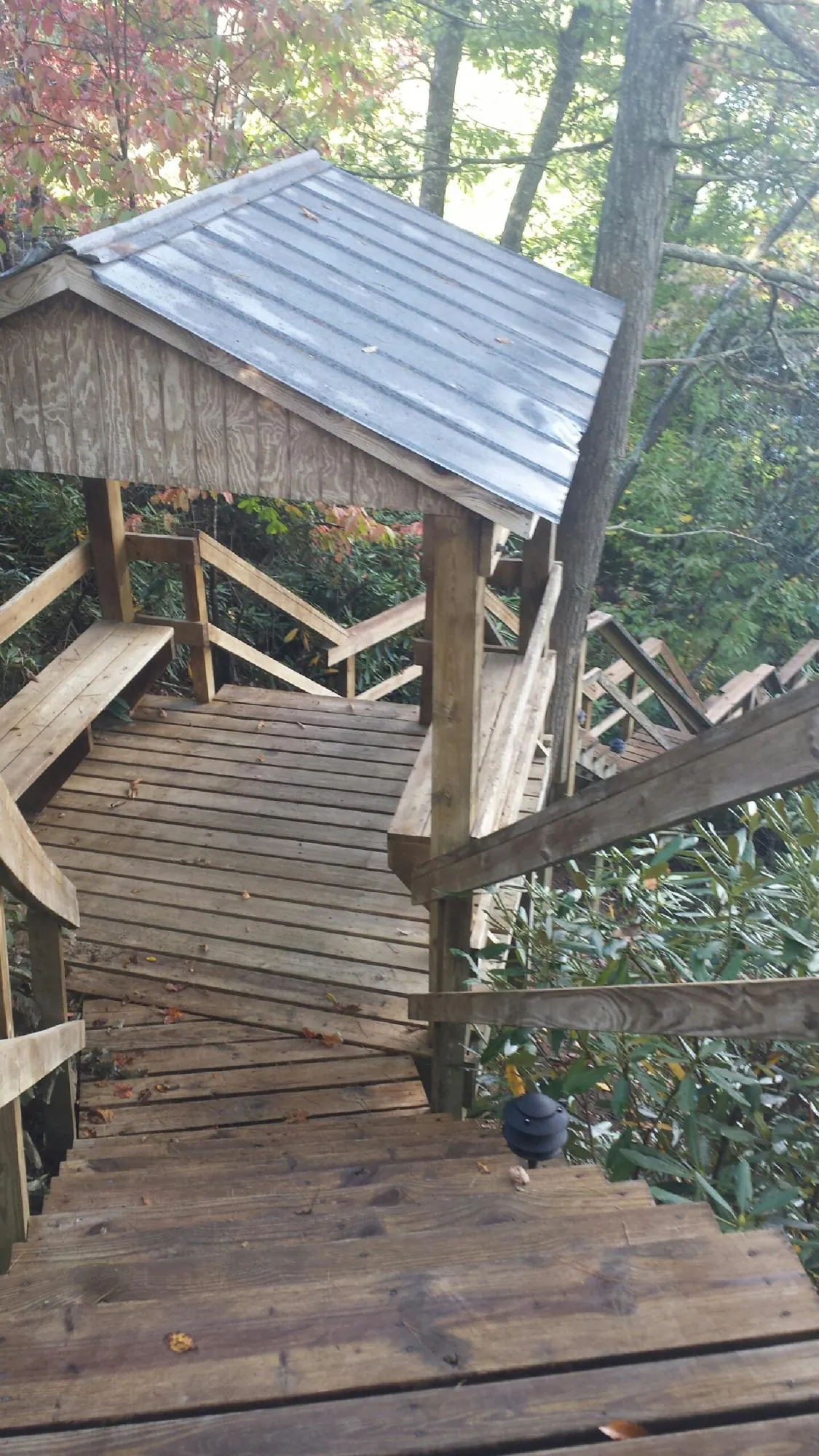 Metal roofed shelter over wooden steps on a wooded walkway — Skylight Repair & Installation work by our crew in Brookfield